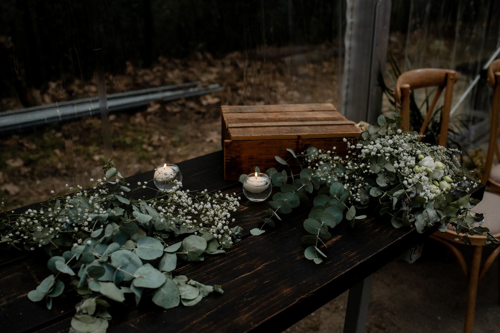 Mesa de boda decorada con ramas de eucalipto y velas encendidas al atardecer