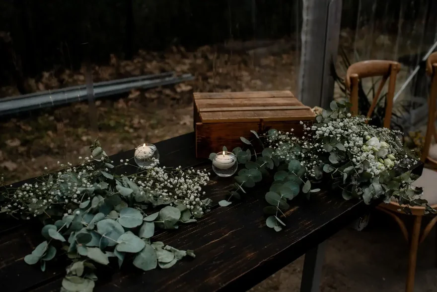 Decoración de mesa Mesa de madera con eucalipto, flores y velas para la decoración de la boda