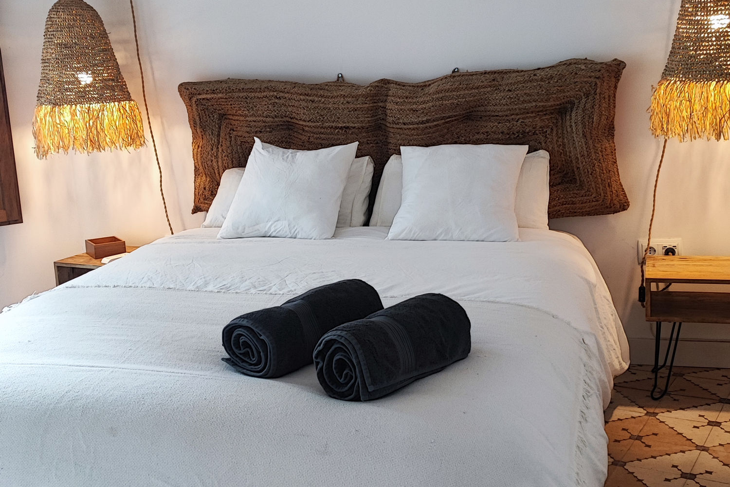 Dormitorio de Casa Chía con cama blanca y cabecero de fibra natural