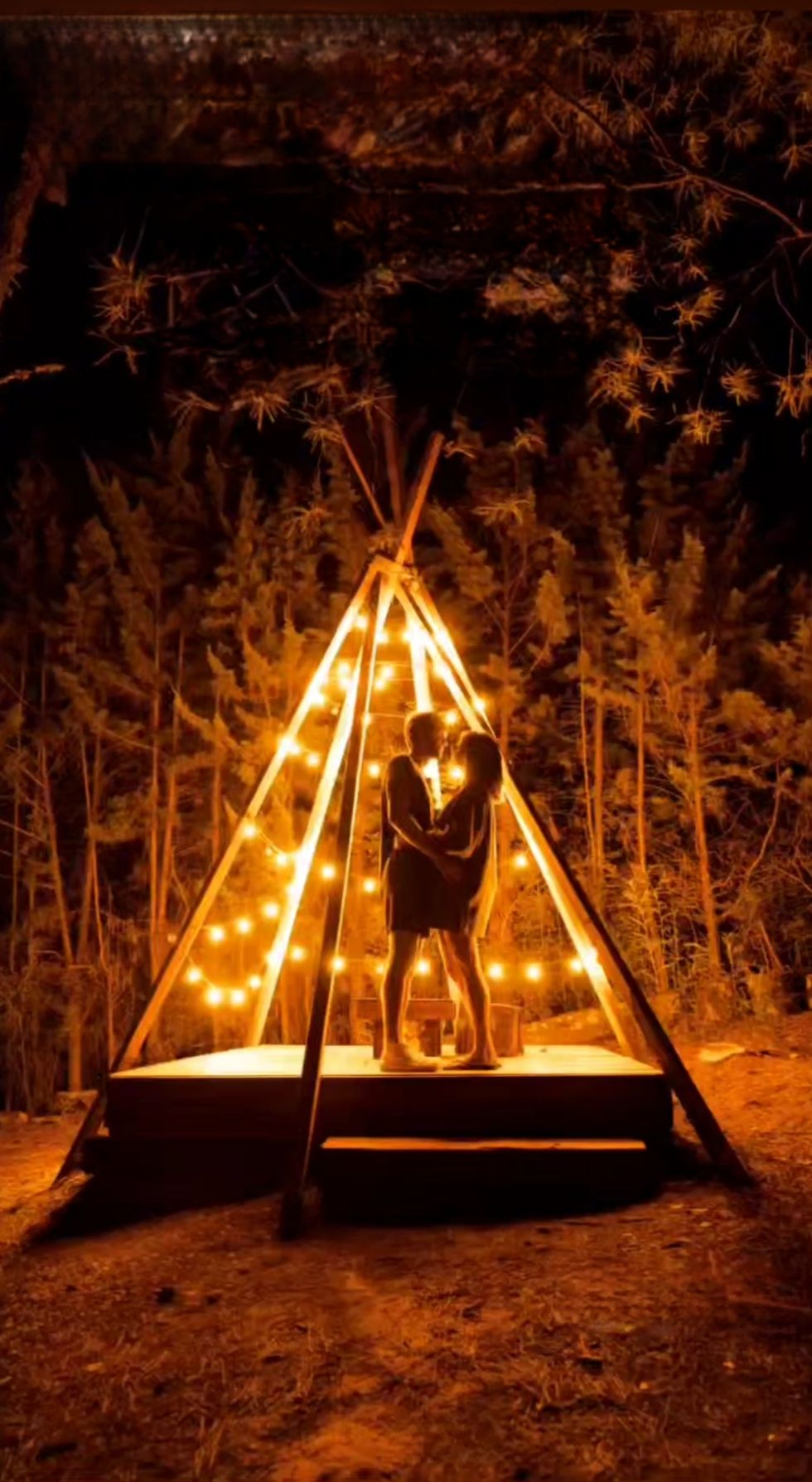 Camino del glamping iluminado con farolillos en la noche del pinar de Gredos
