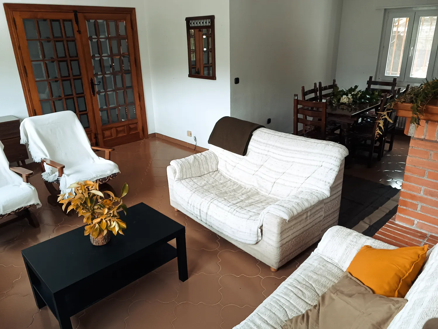 Salón luminoso de Villa Moiko con sofás blancos y chimenea