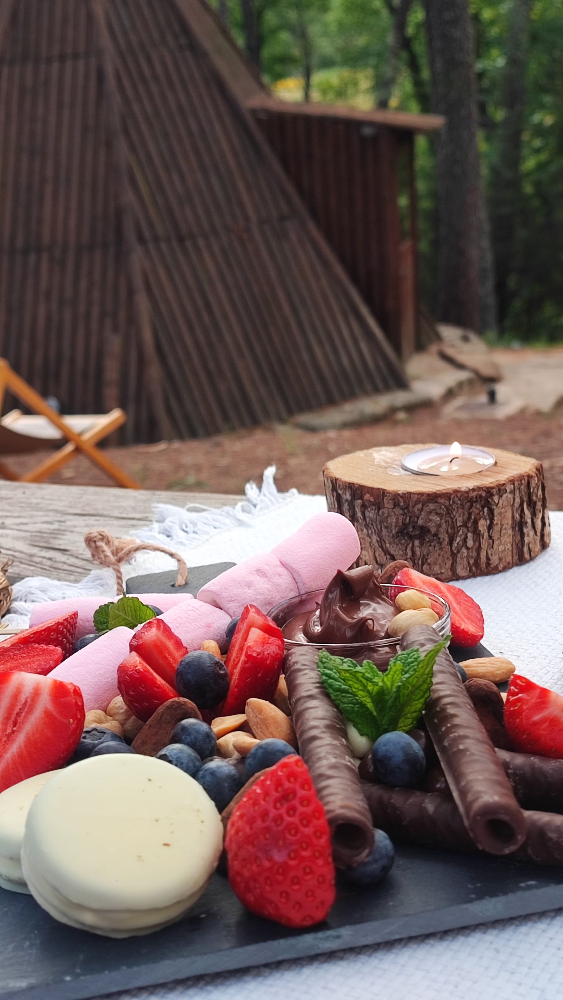 Picnic romántico con velas encendidas al atardecer entre los pinos
