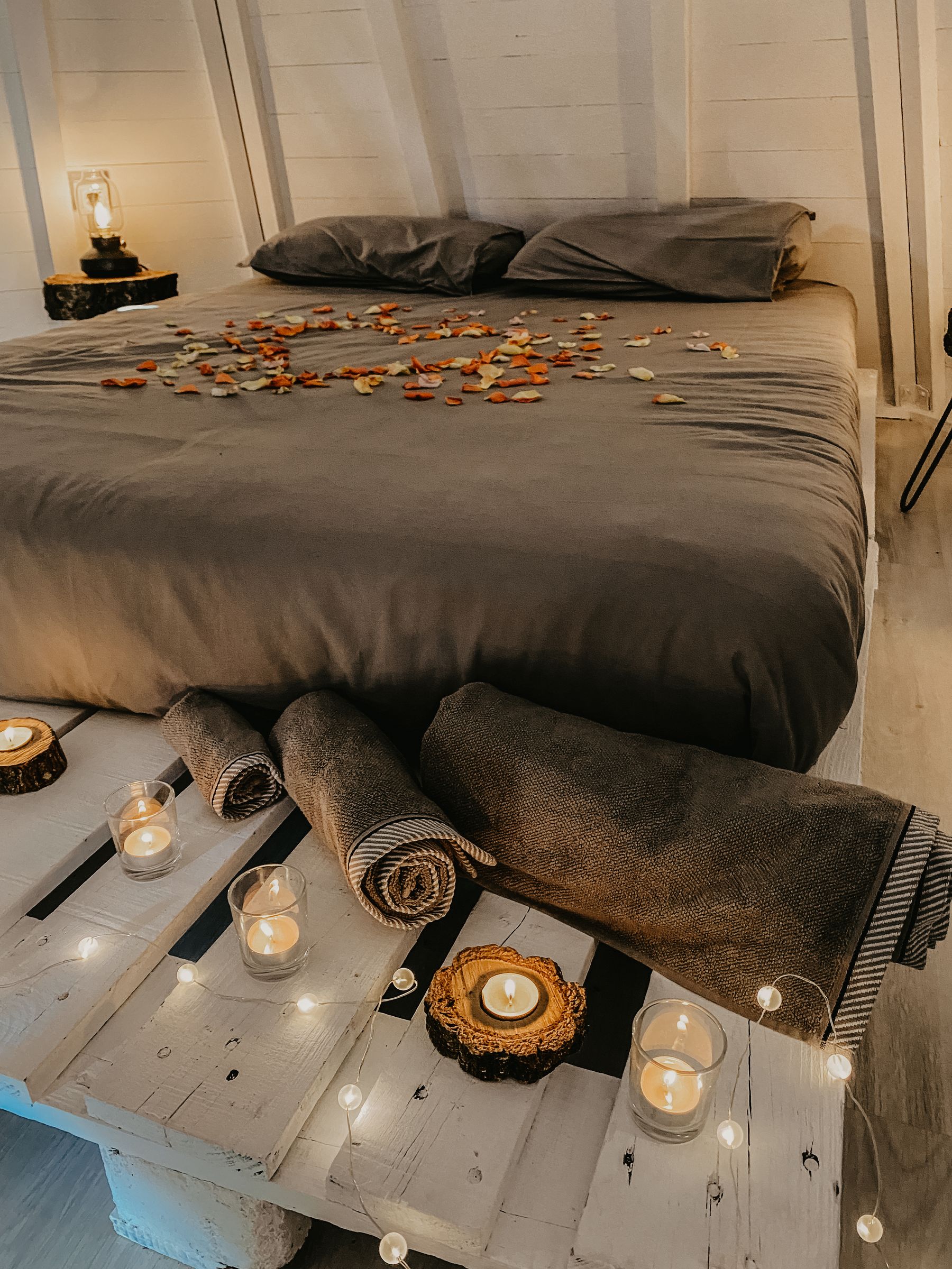 Cama del tipi vestida a la luz cálida de las velas, con textiles naturales