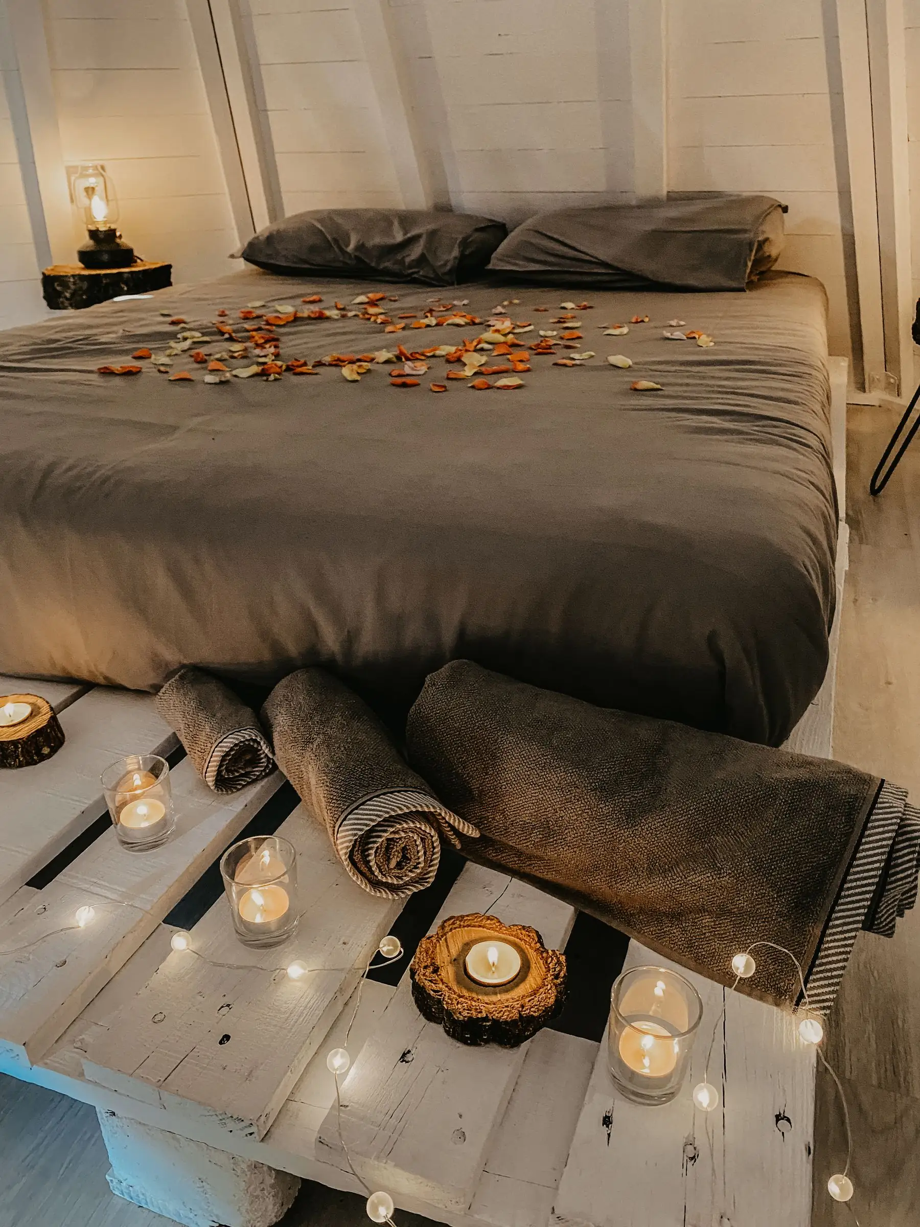 La cama del tipi vestida, con velas encendidas y luz cálida