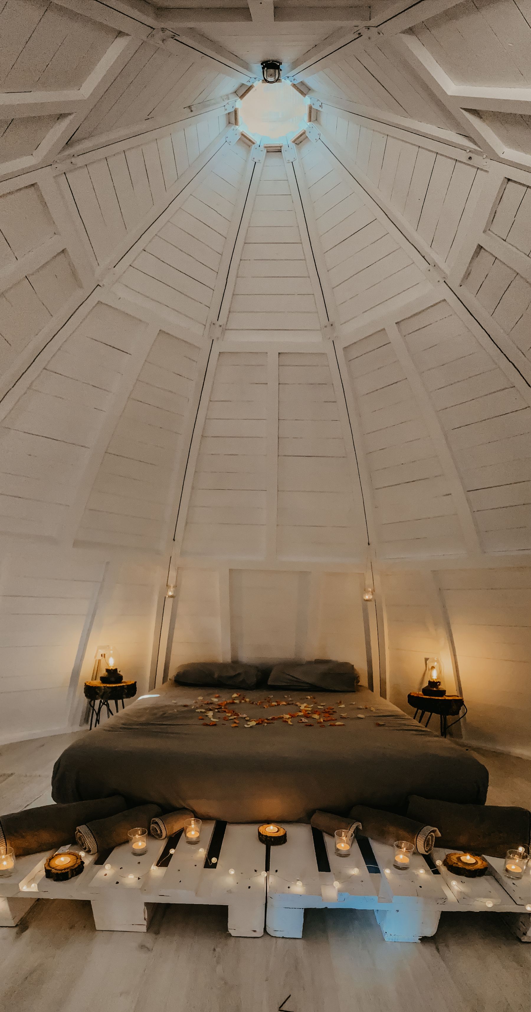 Cama del tipi decorada con pétalos de rosa formando un corazón