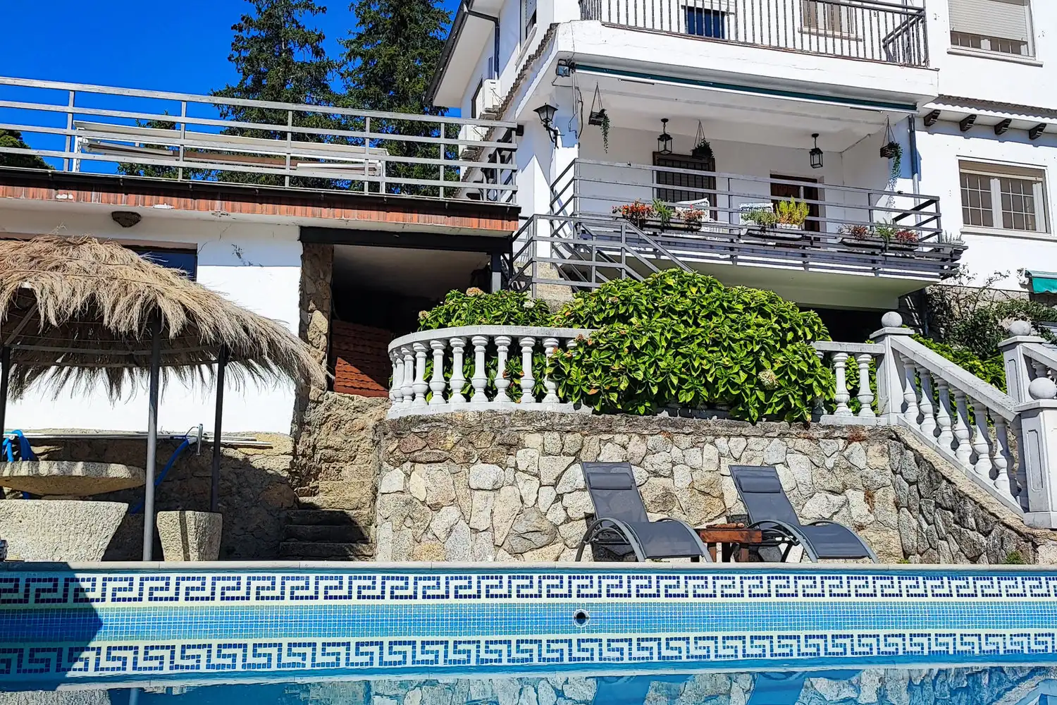Villa Moiko y su piscina Fachada de Villa Moiko con terraza, sombrilla de paja y piscina